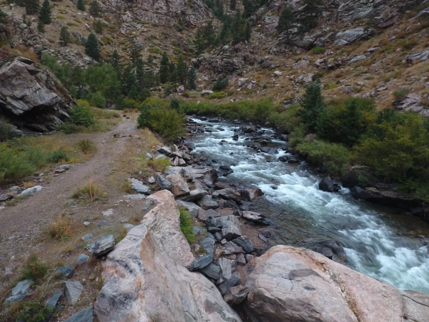 Aerial view of mountain river flowing through rocky canyon with pocket water and boulders